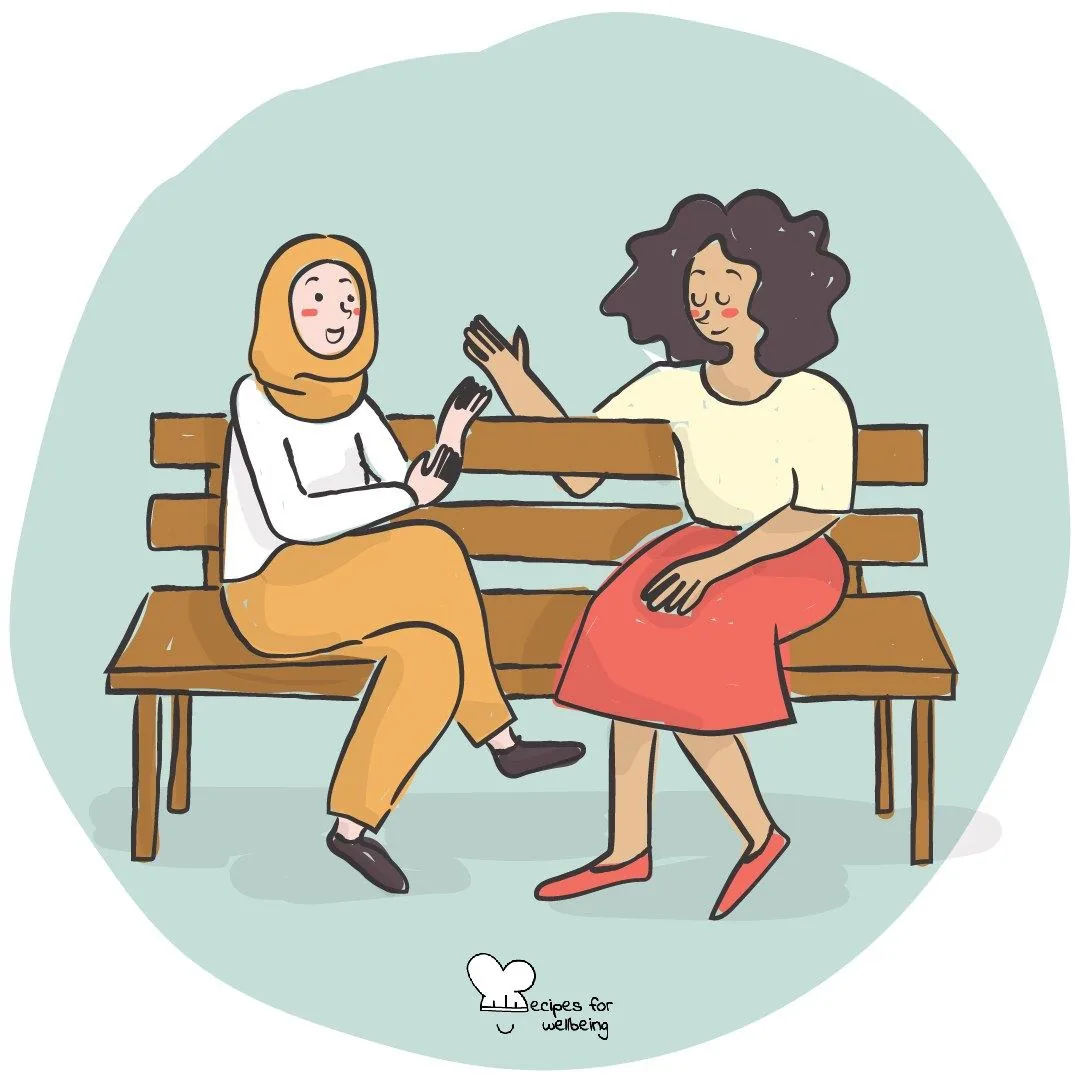 Two people sitting together on a bench, talking