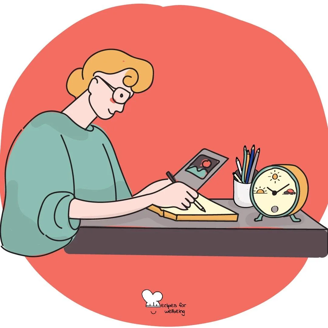 A person writing at a desk beside an alarm clock and a pot of pens