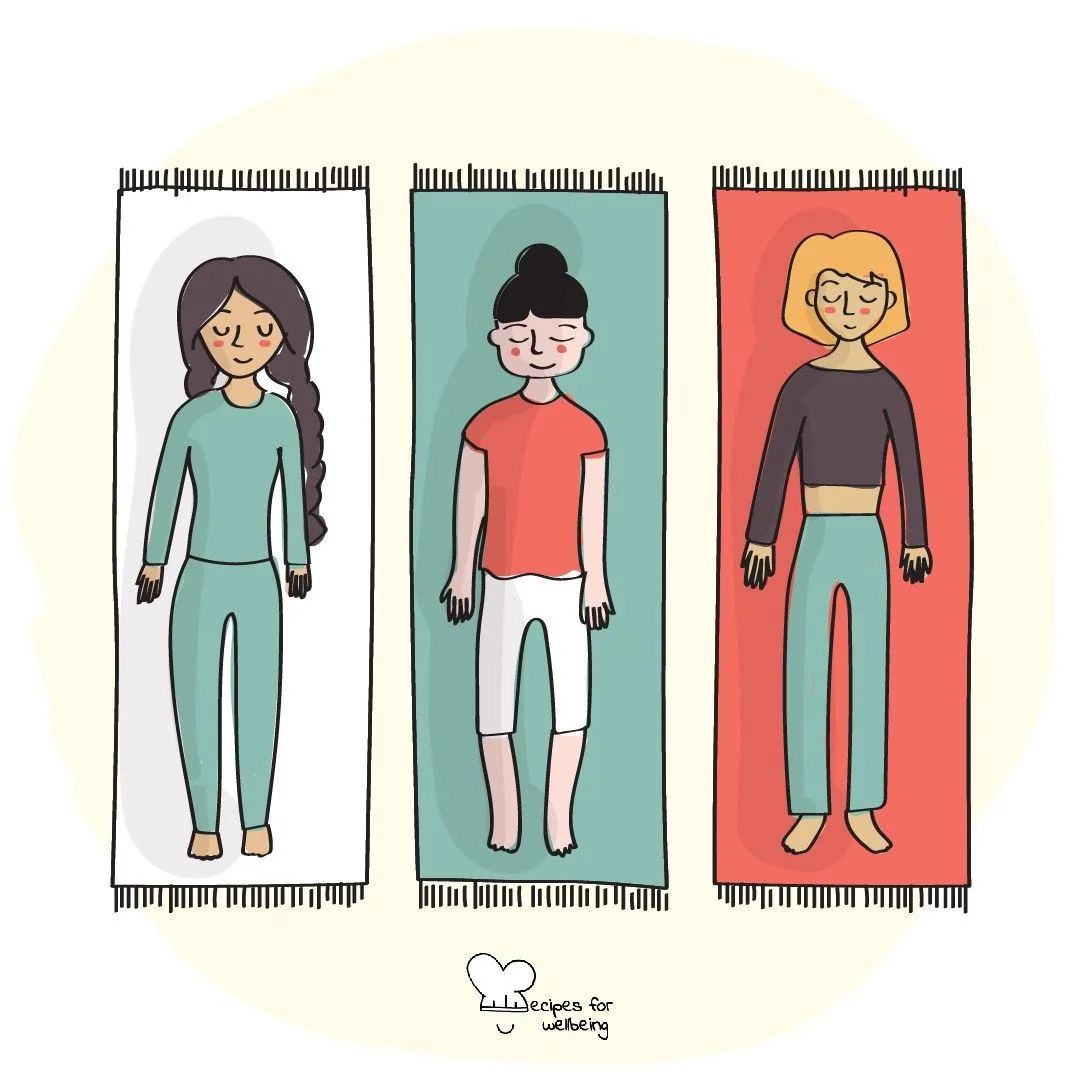 Three people lying on yoga mats with their eyes closed