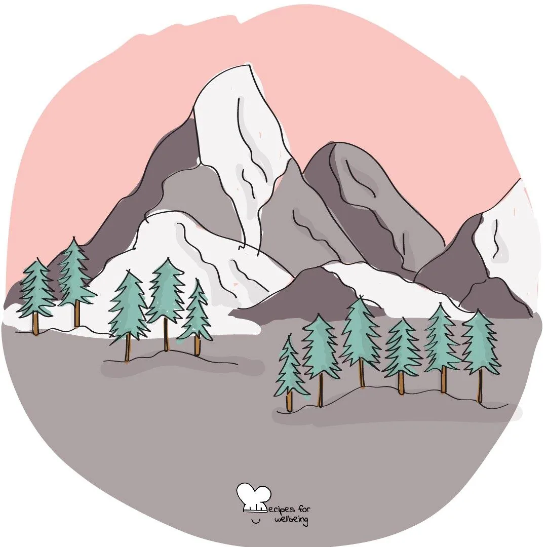 Snow-topped mountains and pine trees under a grey sky