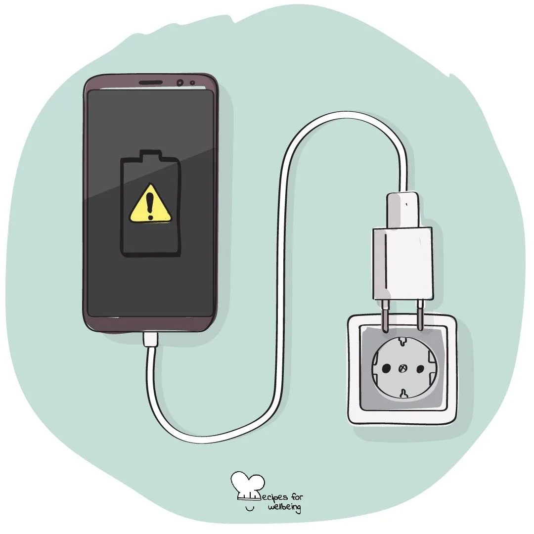 A phone showing a low-battery warning, its cable running to a wall socket