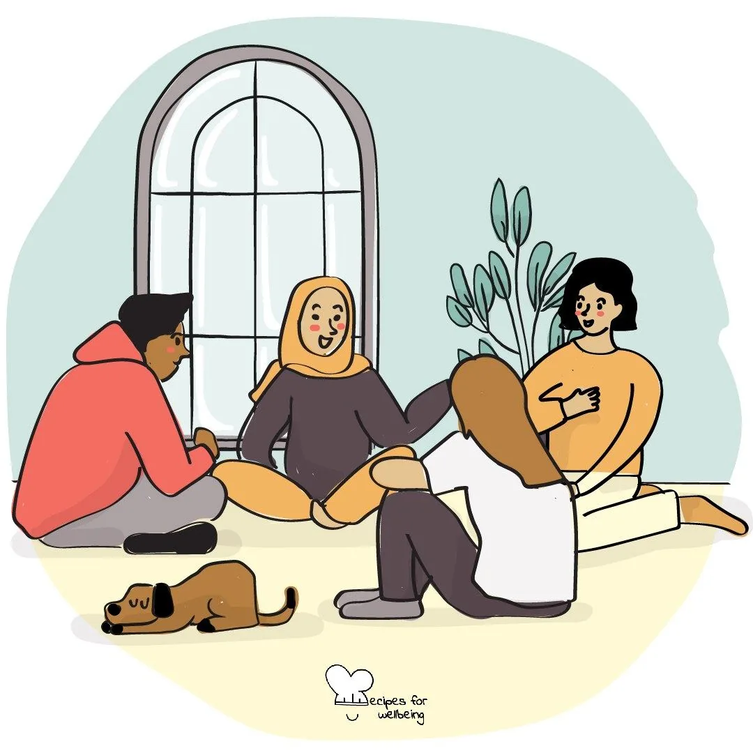 A group sitting together on the floor beside a tall window
